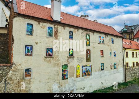 Vivaci graffiti sulle finestre e sulle pareti di una vecchia casa con tegole, Bratislava, Slovacchia, Europa Foto Stock