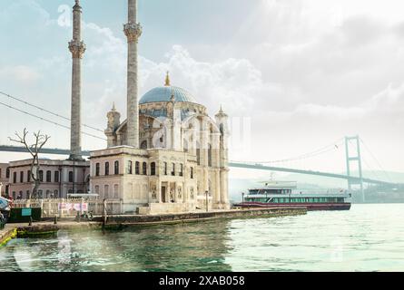 Moschea di Ortakoy illuminata dai raggi del sole con il clima nuvoloso, Istanbul, Turchia, Europa Foto Stock