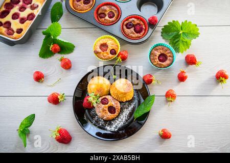 Muffin dolci con ripieno di fragole, in un piatto su un tavolo di legno. Foto Stock