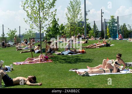 Migliaia di visitatori sul prato della penisola di Gansevoort nell'Hudson River Park di New York, si godranno il fine settimana del Memorial Day di domenica 26 maggio 2024. Il tempo caldo e il sole hanno preso il sopravvento nei primi due giorni, mentre il lunedì del Memorial Day dovrebbe essere nuvoloso e piovoso. (© Richard B. Levine) Foto Stock