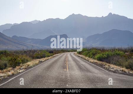 Una strada dritta porta all'orizzonte alle Chisos Mountains presso il Big Bend National Park in Texas Foto Stock