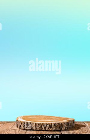 stile naturale. Sega per legno, podio rotondo su un tavolo in legno su un morbido sfondo blu. STILL Life per la presentazione dei prodotti, spazio di copia. Verticale Foto Stock