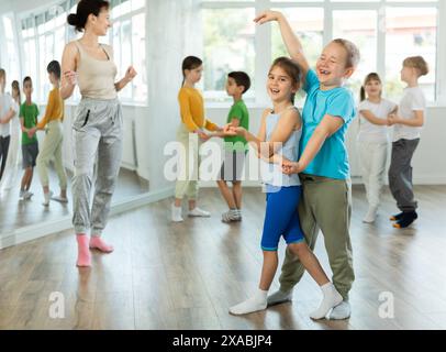 I bambini in età preadolescente imparano a ballare il valzer in coppia nella classe di coreografia Foto Stock