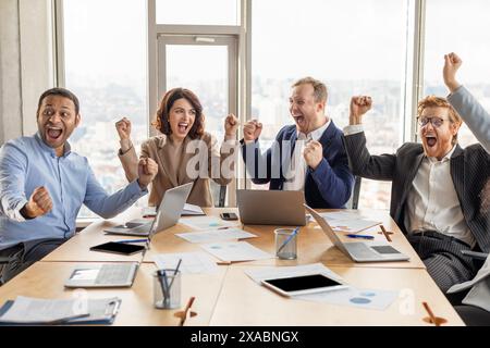 Team aziendale entusiasta che celebra il successo in Modern Office Foto Stock