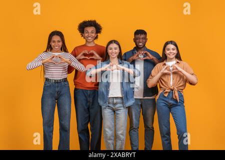 Cinque diversi giovani adulti che creano forme cardiache con le mani Foto Stock