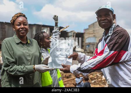 Nyaguthii Chege (L) del movimento Green Belt presenta sostegno a Humphrey Omukuti (R) fondatore di Ghetto Farmers Mathare (GHM) un collettivo di residenti Mathare che lavorano insieme nell'agricoltura concentrando la riabilitazione del fiume Nairobi. Durante un evento di piantagione di alberi in occasione della giornata Mondiale dell'ambiente 2024 presso Kiamaiko slum, a Nairobi, Kenya, il 5 giugno 2024. La giornata mondiale dell'ambiente si celebra ogni anno il 5 giugno e incoraggia la consapevolezza e l'azione a favore della protezione dell'ambiente. Il tema del 2024 è il ripristino del territorio, la desertificazione e la resilienza alla siccità. Foto Stock