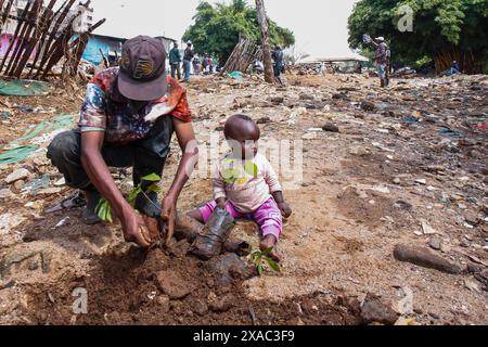 Nairobi, Kenya. 5 giugno 2024. Un residente locale della baraccopoli di Kiamako prende parte alla piantagione di un albero vicino a un sito di case distrutte dalle inondazioni lungo la riva del fiume Mathare durante le celebrazioni in occasione della giornata mondiale dell'ambiente, che si celebra ogni anno il 5 giugno e incoraggia la consapevolezza e l'azione per la protezione dell'ambiente. Il tema del 2024 è il ripristino del territorio, la desertificazione e la resilienza alla siccità. Credito: SOPA Images Limited/Alamy Live News Foto Stock