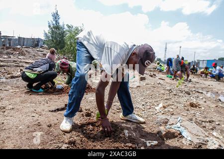 Nairobi, Kenya. 5 giugno 2024. Un residente locale della baraccopoli di Kiamako prende parte alla piantagione di un albero vicino a un sito di case distrutte dalle inondazioni lungo la riva del fiume Mathare durante le celebrazioni in occasione della giornata mondiale dell'ambiente, che si celebra ogni anno il 5 giugno e incoraggia la consapevolezza e l'azione per la protezione dell'ambiente. Il tema del 2024 è il ripristino del territorio, la desertificazione e la resilienza alla siccità. (Foto di Boniface Muthoni/SOPA Images/Sipa USA) credito: SIPA USA/Alamy Live News Foto Stock