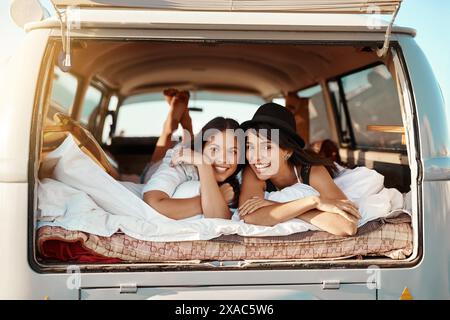 Viaggio su strada, relax e ritratto delle donne in pulmino per vacanze estive, viaggi e avventura in campagna. Felice, gente e amici con la coperta dentro Foto Stock