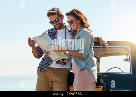 Lettura, associazione e mappatura all'aperto per la navigazione, la ricerca della posizione e la destinazione per il viaggio su strada. Gente felice, uomo e donna con carta da guida Foto Stock