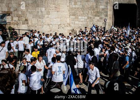 Un agente di polizia israeliano arresta un'ala destra fuori dalla porta di Damasco a Gerusalemme dopo aver gettato bottiglie d'acqua ai giornalisti. Decine di migliaia di giovani religiosi ultranazionalisti, uomini e donne sionisti hanno sfilato attraverso le parti musulmane della città Vecchia di Gerusalemme nella marcia annuale della bandiera di Gerusalemme, un evento che minaccia di innescare ulteriori violenze nella guerra Israele-Hamas. Israelís giorno di Gerusalemme segna la riunificazione della città durante la Guerra dei sei giorni e la cattura del Monte del Tempio e del muro Occidentale, Judaismís luoghi più sacri. Foto Stock