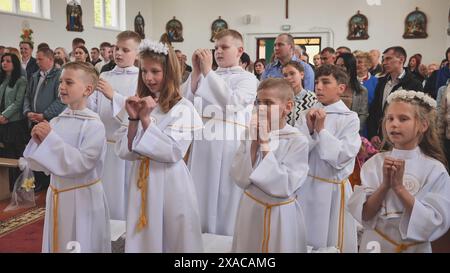 Pervomaysk, Bielorussia - 17 giugno 2022: I bambini cantano alla loro prima comunione cattolica. Foto Stock