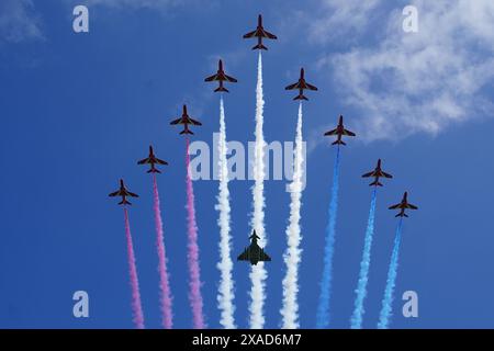 Le frecce rosse con un velivolo Typhoon FGR4 eseguono un flypast durante l'evento commemorativo nazionale del Regno Unito per il 80° anniversario del D-Day, tenutosi presso il British Normandy Memorial di Ver-sur-Mer, Normandia, Francia. Data foto: Giovedì 6 giugno 2024. Foto Stock