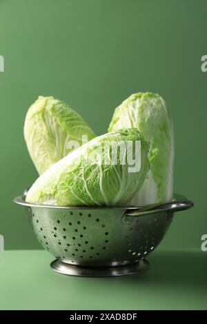 Cavoli cinesi freschi in colino su sfondo verde Foto Stock