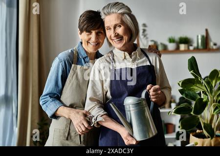 Due donne in grembiuli in piedi insieme in cucina. Foto Stock