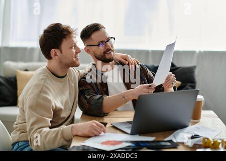 Due uomini in un laboratorio di designer che lavorano insieme su un portatile. Foto Stock