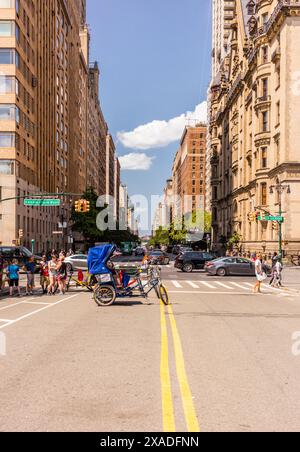 New York City, Stati Uniti - 24 agosto 2017: Auto, persone e una bici taxi a Central Park West, con prospettiva. Foto Stock