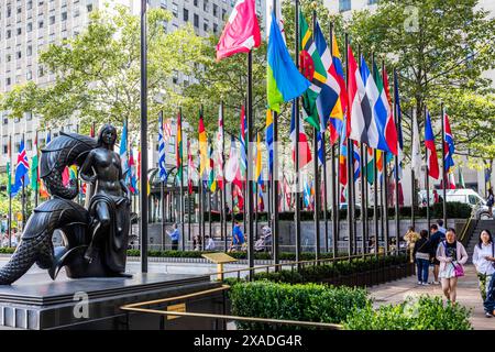 New York City, Stati Uniti - 25 agosto 2017: Turisti, bandiere e statua al Rockefeller Center. Foto Stock