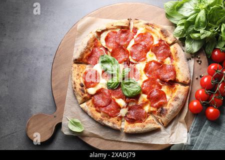 Gustosa pizza al peperoni e ingredienti sul tavolo grigio, vista dall'alto Foto Stock