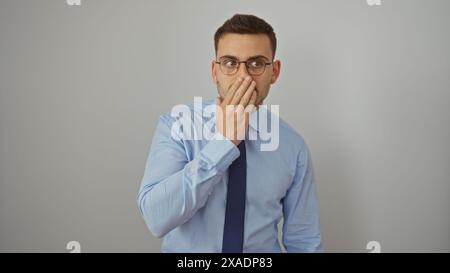 Bel giovane ispanico con barba in camicia azzurra e cravatta, isolato su uno sfondo bianco, con un'espressione pensiva. Foto Stock