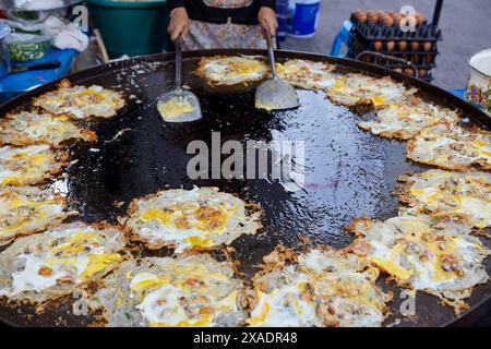 Cozze fritte con uovo in padella al mercato di strada Foto Stock