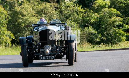 Stony Stratford, Regno Unito - 2 giugno 2024: 1924 auto d'epoca Bentley verde che guida su una strada di campagna britannica Foto Stock