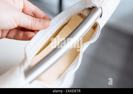 la mano della donna mostra una cerniera lacerata, danneggiata, Foto Stock