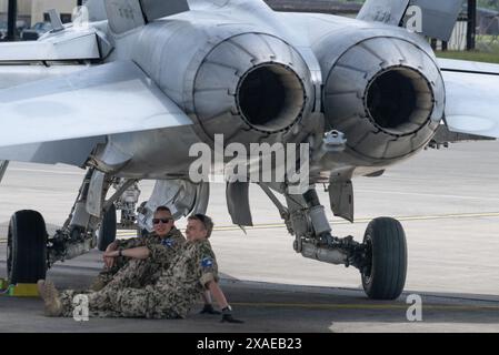 Ramstein, Germania. 6 giugno 2024. I soldati si rilassano all'ombra di un jet da caccia come parte di un'esercitazione su larga scala presso la base aerea americana di Ramstein. L’esercizio è inteso a rafforzare la capacità di cooperare all’interno delle forze aeree. Credito: Boris Roessler/dpa/Alamy Live News Foto Stock