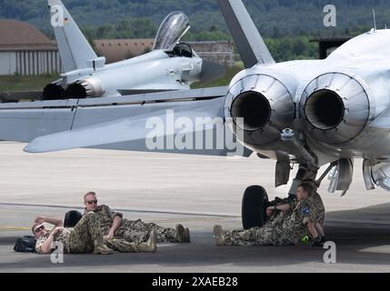 Ramstein, Germania. 6 giugno 2024. I soldati si rilassano all'ombra di un jet da caccia come parte di un'esercitazione su larga scala presso la base aerea americana di Ramstein. L’esercizio è inteso a rafforzare la capacità di cooperare all’interno delle forze aeree. Credito: Boris Roessler/dpa/Alamy Live News Foto Stock