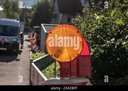 un cartello arancione riflettente in primo piano dei lavori di costruzione di strade Foto Stock