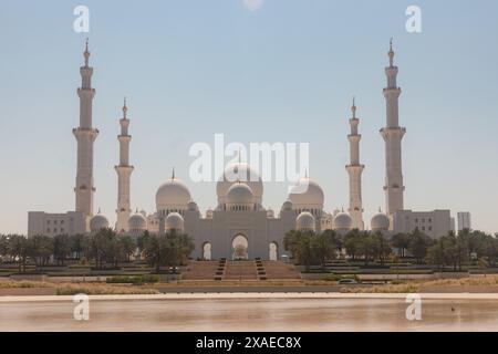 Una vista della grande Moschea dello Sceicco Zayed con palme al tramonto. Grande Moschea dello sceicco Zayed ad Abu Dhabi, Emirati Arabi Uniti. Foto Stock