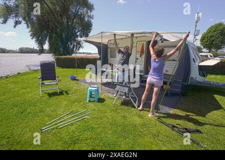 Paesi Bassi, Slijk-Ewijk, 5-6-2024 gli ospiti del campeggio mettono in valigia la propria roulotte al campeggio Grote Altena vicino a Oosterhout e Nijmegen. Qui l'acqua nel Waal è salita fino alle piazzole di carovane e tende a causa della forte pioggia che è caduta in Germania. Nei prossimi giorni l'acqua salirà al campeggio e domani le piazzole vicino all'acqua dovrebbero essere vuote. Foto: ANP/ Hollandse Hoogte/ Flip Franssen netherlands Out - belgium Out Foto Stock