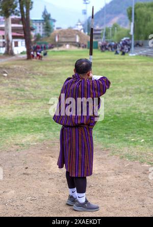 L'uomo bhutanese punta freccia nella competizione di tiro con l'arco, Chang Gewog, Thimphu, Bhutan Foto Stock