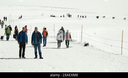 Un gruppo di persone sta camminando su un sentiero innevato Foto Stock