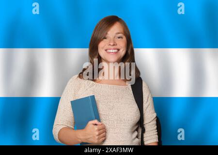 Donna felice studentessa contro sfondo bandiera argentina. Viaggio, istruzione e apprendimento della lingua in Argentina concetto Foto Stock