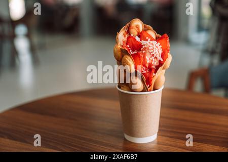 Fai bollire i waffle in una tazza con gelato e fragole Foto Stock