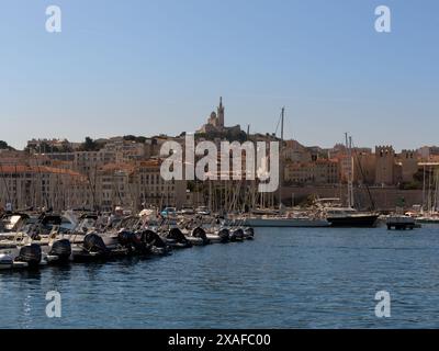 MARSIGLIA, FRANCIA - 19 MAGGIO 2024: Vista sul Porto Vecchio con la Basilica di Notre-Dame de la Garde sullo sfondo Foto Stock