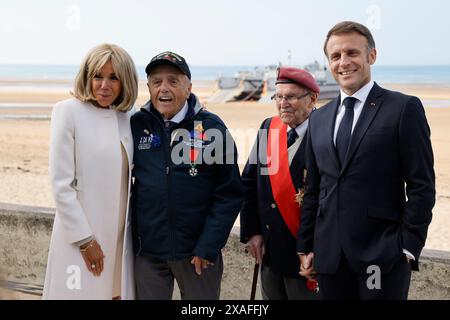 Il presidente francese Emmanuel Macron (R), la moglie del presidente francese Brigitte Macron (L) posa con il veterano statunitense Andy Negra (2ndL), e il veterano francese Achille Muller, ultimo sopravvissuto delle forze francesi libere, durante la cerimonia commemorativa internazionale a Omaha Beach in occasione del 80° anniversario dello sbarco alleato del D-Day della seconda guerra mondiale in Normandia, a Saint-Laurent-sur-Mer, nel nord-ovest della Francia, il 6 giugno 2024. Le cerimonie del D-Day del 6 giugno di quest'anno celebrano il 80° anniversario dal lancio dell'operazione Overlord, una vasta operazione militare delle forze alleate in Normandia, che si è svolta Foto Stock