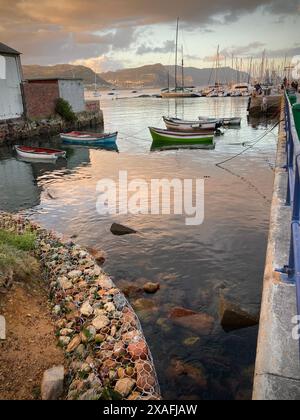 Piccole barche ormeggiate lungo il molo di Simon's Town in prima serata. Acqua tranquilla. Foto Stock