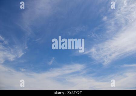 Wispy nubi in un cielo blu Foto Stock