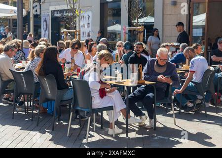 Valencia, Spagna - 24 marzo 2024: Le persone mangiano al ristorante seduti fuori ai tavoli Foto Stock