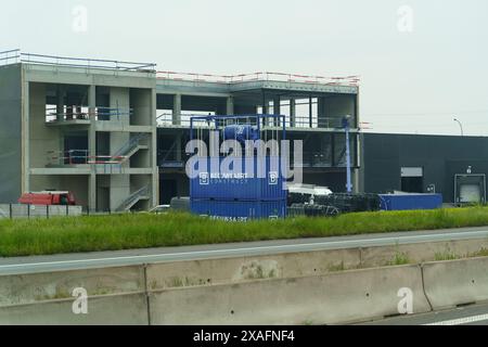 Waregem, Belgio - 22 maggio 2023: Una scultura di rinoceronte blu si trova di fronte a un edificio in cemento in costruzione in Belgio. Foto Stock