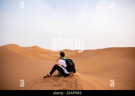 Un escursionista solitario percorre le dune di sabbia di Erg Chigaga, vicino a M'Hamid, Marocco Foto Stock