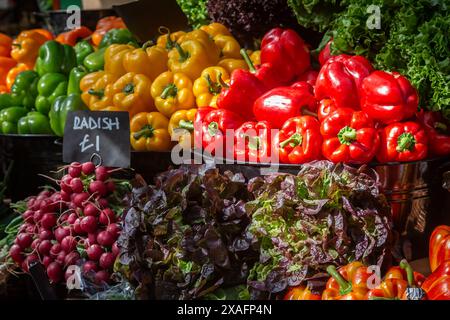 Peperoni vivaci e insalata pronte per essere vendute in una bancarella di mercato Foto Stock