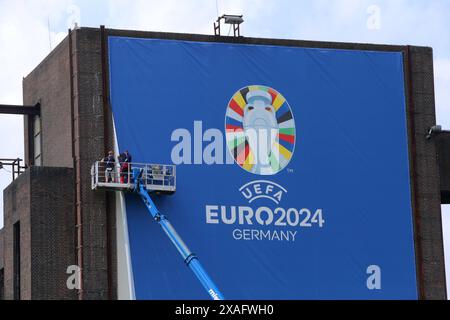 06.06.2024 Gelsenkirchen, Das Gelände der Zeche Nordstern ist ein ehemaliges Steinkohlenbergwerk a Gelsenkirchen-Horst. während der EURO24 ist hier eine Fanzone vorgesehen, es soll auch ein Public Viewing statt finden. Ein riesige Banner un einem ehemaligen Kohlebunker wirbt für das internationale Ereignis. *** 06 06 2024 Gelsenkirchen, il sito della miniera di carbone Nordstern è un'ex miniera di carbone a Gelsenkirchen Horst Una fan zone è prevista qui durante EURO24, e un evento pubblico di visualizzazione avrà luogo anche Un enorme striscione su un ex bunker di carbone pubblicizza l'evento internazionale Foto Stock