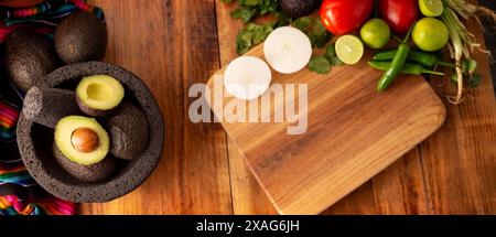 Ingredienti di base per preparare la salsa di avocado conosciuta come guacamole, realizzata in una molcajete di pietra vulcanica, una salsa molto popolare a base di avocado. Ricetta tradizionale Foto Stock