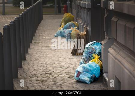 Una collezione di borse per la spazzatura allineate su una strada di Liegi, Belgio, in attesa di essere raccolte. Questa immagine riflette il sistema di gestione dei rifiuti urbani in pla Foto Stock