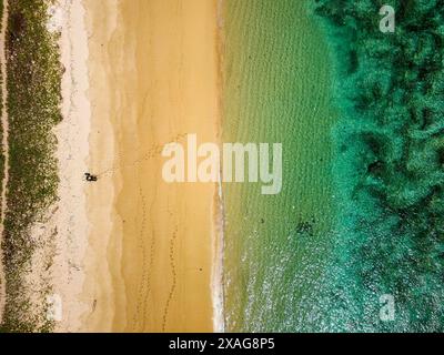Vista dall'alto verso il basso di una spiaggia tropicale deserta e di un oceano caldo e poco profondo Foto Stock