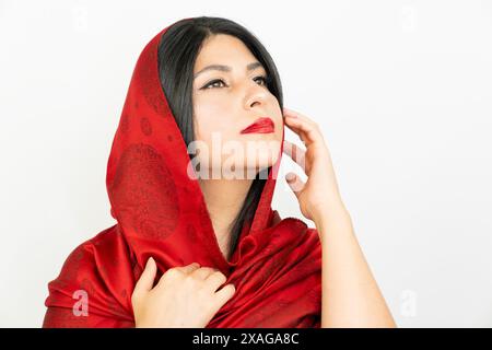 Ritratto di una donna con una sciarpa rossa in studio. giovane donna mediorientale, sfondo bianco Foto Stock
