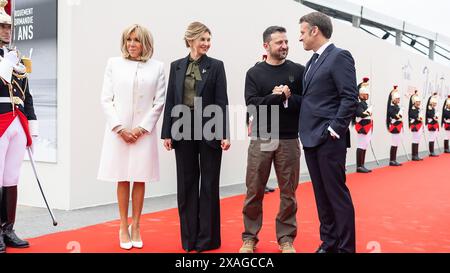 La moglie del presidente francese Brigitte Macron (L) e il presidente francese Emmanuel Macron (R) salutano il presidente ucraino Volodymyr Zelensky (2ndR) e sua moglie Olena Zelenska al loro arrivo per partecipare alla cerimonia commemorativa internazionale a Omaha Beach in occasione del 80° anniversario dello sbarco alleato dello "D-Day" della seconda guerra mondiale in Normandia, a Saint-Laurent-sur-Mer, nel nord-ovest della Francia, giovedì 6 giugno 2024. Le cerimonie del D-Day del 6 giugno di quest'anno celebrano il 80° anniversario dal lancio dell'operazione Overlord, una vasta operazione militare delle forze alleate in Normandia, che ha cambiato la sorte Foto Stock